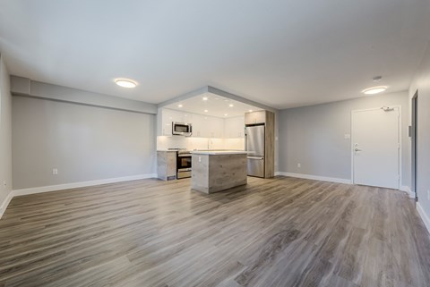 the living room and kitchen in a new home with wood flooring